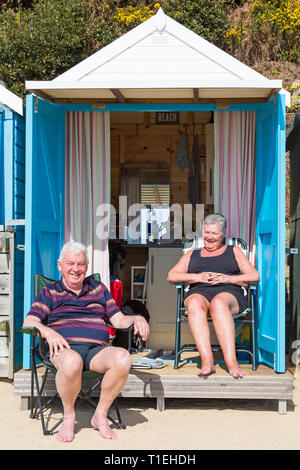 Bournemouth, Dorset, UK. Mar 26, 2019. Météo France : une autre belle chaude journée ensoleillée avec un ciel bleu et soleil à plages de Bournemouth, en tant que visiteurs, chef de la station pour profiter au maximum de la météo radieuse. Young couple relaxing at beach hut. Credit : Carolyn Jenkins/Alamy Live News Banque D'Images