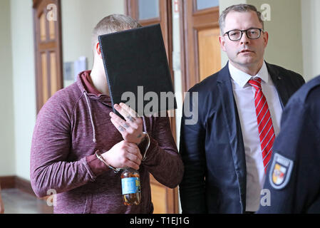 Wismar, Allemagne. Mar 26, 2019. Le défendeur dans le procès d'une attaque contre une république est prise à la salle d'audience du tribunal de district, de même que son avocat Thomas Penneke. Le ministère public accuse un homme de Wismar menace de lésions corporelles graves et dangereuses. En août 2018, il est dit avoir attaqué un puis 20 ans République dans un parc de Wismar, frappé à terre et battu. Crédit : Bernd Wüstneck/dpa/Alamy Live News Banque D'Images