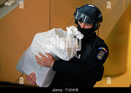 Bucarest, Roumanie. Mar 26, 2019. Un agent de la police spéciale roumaine porte un sac de cocaïne dans l'immeuble de la direction de l'Enquête sur le crime organisé et le terrorisme (DIICOT) à Bucarest, Roumanie, le 26 mars 2019. La police roumaine ont saisi plus de 1 000 kilogrammes de cocaïne d'une grande pureté dans le Delta du Danube, avec une valeur de marché noir de quelque 340 millions de dollars américains, le pays pour lutter contre le crime organisé a annoncé mardi. Credit : Cristian Cristel/Xinhua/Alamy Live News Banque D'Images