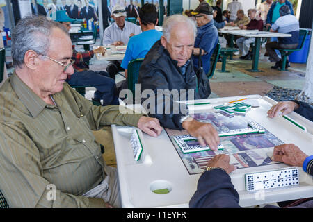 Miami Florida,Little Havana,Calle Ocho,Maximo Gomez Domino Park,Hispanic man hommes,senior seniors citoyens,foursome,groupe,dominos,carrelage,gam Banque D'Images