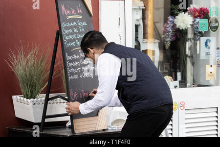 Waiter writing menu del dia, [menu du jour] le tableau situé à l'extérieur restaurant à Vegueta, Las Palmas, Gran Canaria, Îles Canaries, Espagne Banque D'Images