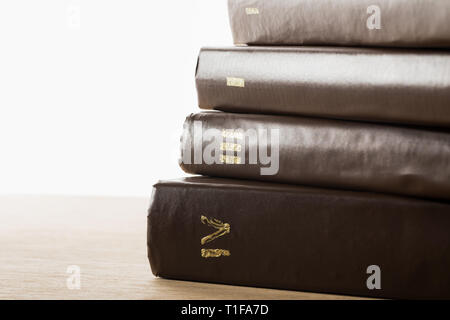 Volumes de livres en cuir brown couvre sur table en bois isolé sur blanc Banque D'Images