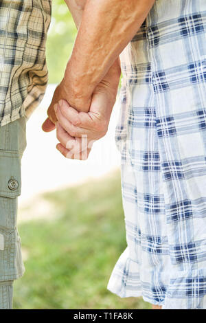 Senior couple marche main dans la main dans la nature comme un symbole de l'amour et de loyauté Banque D'Images