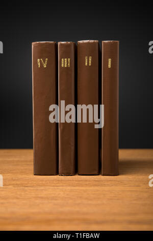 Volumes de livres rétro en cuir brown couvre sur table en bois isolé sur black Banque D'Images