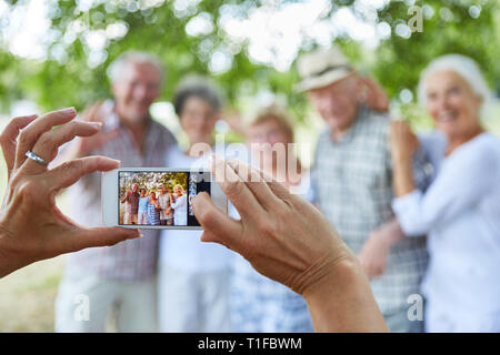 Personne prend une photo d'un groupe de personnes âgées en vacances avec son smartphone Banque D'Images