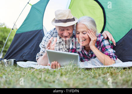Senior couple having fun at le chat vidéo en ligne avec l'ordinateur tablette en camping Banque D'Images