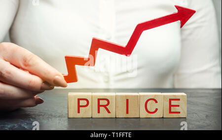 Une femme tient une flèche rouge au-dessus des blocs de bois et le prix d'inscription. La valeur de marché en croissance. L'établissement des prix. L'économie de marché. L'inflation. Pri des consommateurs Banque D'Images