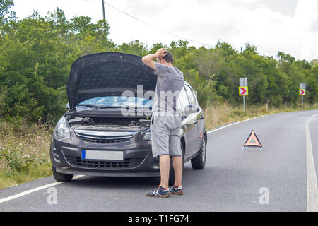 Location de dysfonctionnement sur la campagne. Location en attente de l'aide sur la route. Panne de voiture. Homme avec panne de voiture. En attente de l'assistance routière Banque D'Images