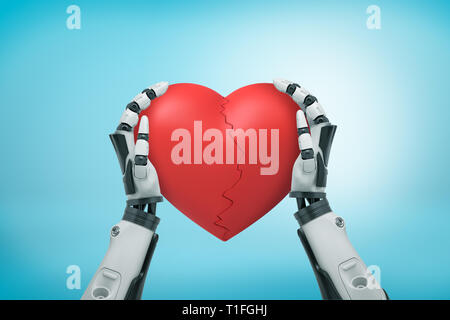 Vue de dessus du robot noir et blanc hands holding big red Valentine fissuré dans la moitié sur fond bleu clair. Banque D'Images