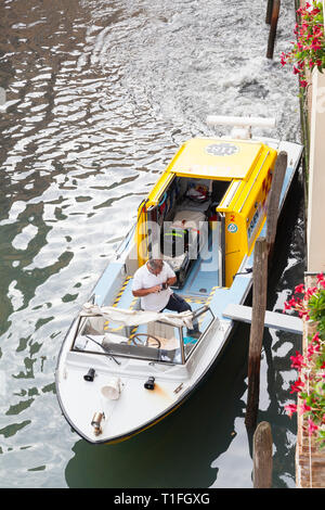 Ambulance vénitienne en attente dans un canal de collecte d'un patient, Venise, Vénétie, Italie, de haut en bas avec les membres du personnel dans le bateau et vue d'i Banque D'Images