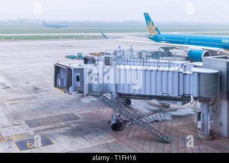 Pont d'embarquement ou de jet pont sur la préparation par l'équipage de service au sol pour les écarter ou arriver à l'aéroport international de Noi Bai à Hanoi, Vietnam. Banque D'Images