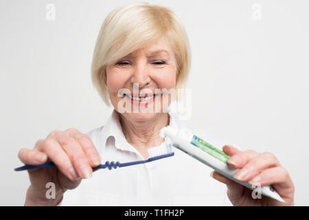 Close up et cut vuew d'une femme mettant certains dentifrice sur la brosse à dents. Elle veut nettoyer ses dents. La dame est d'avoir soin de sa bouche Banque D'Images