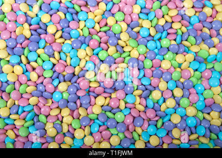 Arrière-plan de chocolats enrobés de sucre dans des tons pastel, thème de Pâques Banque D'Images