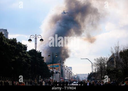 Baku, Azerbaïdjan. Mar 26, 2019. Un hélicoptère s'apprête à déposer de l'eau sur un incendie au marché du Diqlas à Bakou, Azerbaïdjan, le Mardi, Mars 26, 2019. Un grand incendie s'est déclaré ce matin dans le centre commercial "iglas' dans le village de 8 kilomètre à Bakou. Brûler les étages supérieurs de l'édifice de cinq étages. Credit : Aziz Karimov/Pacific Press/Alamy Live News Banque D'Images