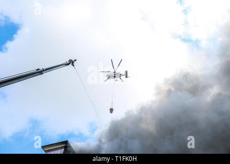 Baku, Azerbaïdjan. Mar 26, 2019. Un hélicoptère s'apprête à déposer de l'eau sur un incendie au marché du Diqlas à Bakou, Azerbaïdjan, le Mardi, Mars 26, 2019. Un grand incendie s'est déclaré ce matin dans le centre commercial "iglas' dans le village de 8 kilomètre à Bakou. Brûler les étages supérieurs de l'édifice de cinq étages. Credit : Aziz Karimov/Pacific Press/Alamy Live News Banque D'Images