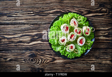 Vue aérienne de tours de sandwichs brochettes. Des roll-ups de grains entiers pain plat avec sauce au yogourt, jambon, fromage, laitue, piment servi sur une bla Banque D'Images