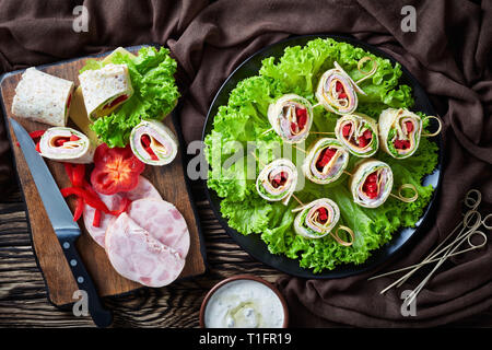 Tours de sandwichs les brochettes sur une assiette. les ingrédients et la crème d'ail sauce dans un bol sur une table en bois rustique avec chiffon brun, vue fronm Banque D'Images