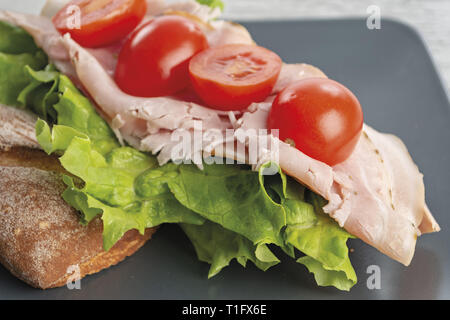 Pane e prosciutto con insalata verde e Pomodori da sopra primo piano Banque D'Images