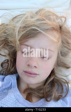 Portrait d'une jeune fille blonde curly dormir paisiblement Banque D'Images