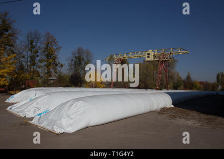 Le thème est l'industrie et agraire. La moisson est stocké dans de grands, imperméables, étanches sacs blancs à l'air libre à l'extérieur de la ferme. Banque D'Images