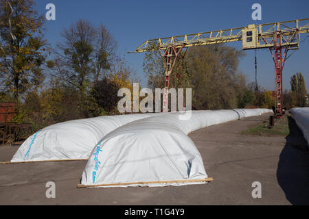 Le thème est l'industrie et agraire. La moisson est stocké dans de grands, imperméables, étanches sacs blancs à l'air libre à l'extérieur de la ferme. Banque D'Images