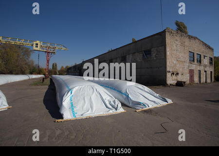 Le thème est l'industrie et agraire. La moisson est stocké dans de grands, imperméables, étanches sacs blancs à l'air libre à l'extérieur de la ferme. Banque D'Images