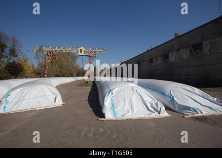 Le thème est l'industrie et agraire. La moisson est stocké dans de grands, imperméables, étanches sacs blancs à l'air libre à l'extérieur de la ferme. Banque D'Images