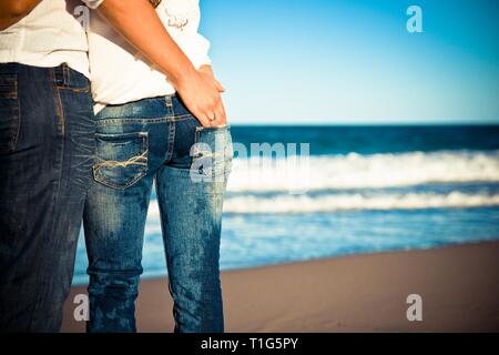 Couple in love adopté par derrière sur la plage Banque D'Images