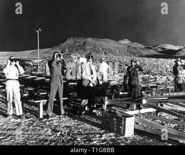 Théière opération test de bombe atomique. Les observateurs canadiens et britanniques illuminée par l'éclat de lumière d'une explosion atomique dans le Nevada Test Site, USA, le 15 avril 1955. Les observateurs sont en utilisant les téléspectateurs de protection pour éviter d'être aveuglé par le rayonnement de la bombe atomique. Le rendement de la bombe était équivalent à 22 000 tonnes de TNT. L'explosion atomique, lui-même nommé réunies (critère des effets militaires), a été le 12e test dans l'exploitation de la série théière. Référence de fichier #  1003 824THA Banque D'Images