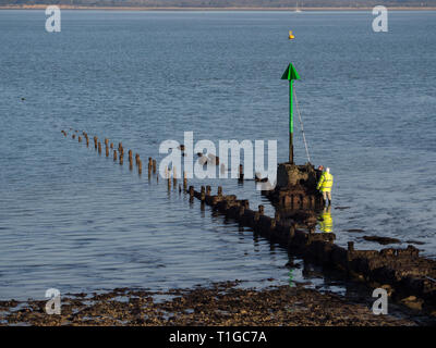 Paire de deux ouvriers hommes travailleurs dans le maintien de travail haute visibilité peinture repeindre avec un rouleau de brosse rallonge épi plage navigation marqueur Banque D'Images