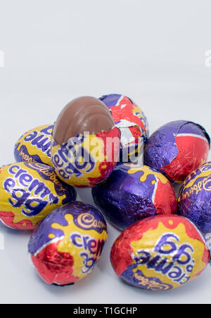 Londres, UK - Mars 2019 : Cadbury creme egg dans différentes tailles dans un emballage coloré montrant un chocolat emballé avec remplissage intérieur blanc et jaune Banque D'Images