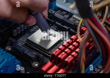 L'application de pâte thermique ingénieur sur le Conseil de l'ordinateur cpu chip Banque D'Images