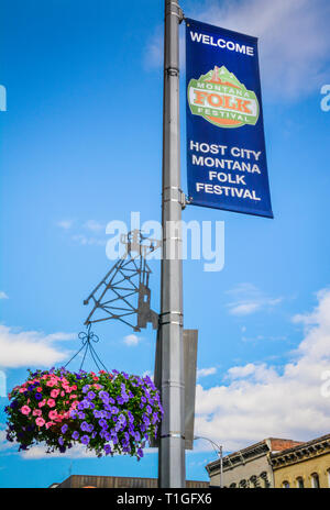 Un signe pour le Montana Folk Festival organisé par l'ancienne ville minière de Butte, MT, avec des fleurs suspendues sur un métal d'art de la découpe du châssis de la tête de Mine Banque D'Images