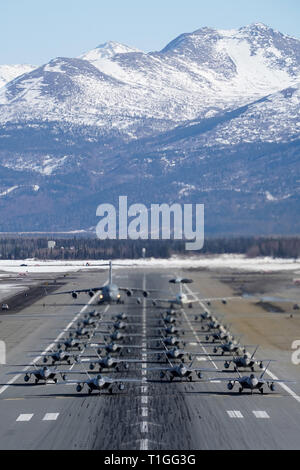 F-22 Raptors à partir de la 3e Escadre et 477th Fighter Group participent à une formation serrée avec un taxi E-3 Sentry et un C-17 Globemaster III, connu comme un éléphant à pied, le 26 mars 2019, au cours d'un exercice de la Force polaire at Joint Base Elmendorf-Richardson, en Alaska. Cet exercice de deux semaines d'escadrons donne l'occasion de démontrer leurs capacités à l'avant de déployer et de livrer combat écrasante. (U.S. Air Force Photo de Justin Connaher) Banque D'Images