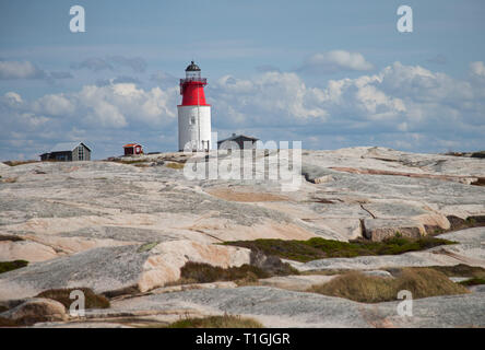 HÅLLÖ 20170817 certains qui marche sur les rochers de l'île de Hållö juste en dehors de Smögen. Hållö phare en arrière-plan. Jeppe Photo Gustafsson Banque D'Images