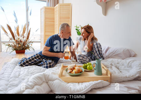 Week-end le petit-déjeuner. Deux hommes d'wearing pajamas profiter de week-end le petit-déjeuner en chambre Banque D'Images