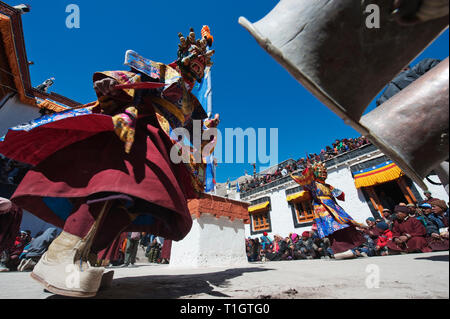 Masque de Mahakala bleu sur l'arrière-plan d'un monastère bouddhiste, Cham, danse sur la droite il y a de grandes trompettes Bouddhiste. Banque D'Images