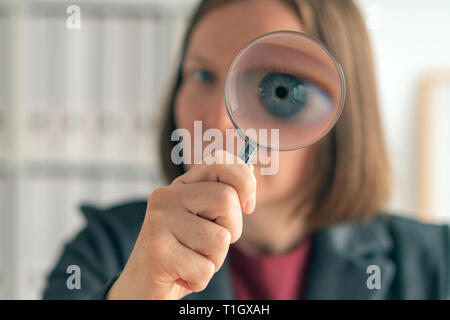 Businesswoman with magnifying glass font des affaires d'audit financier, l'examen et l'évaluation des états financiers. Banque D'Images