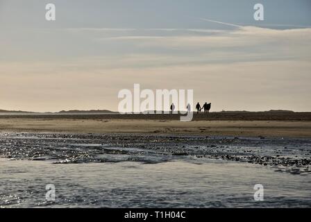 Chiffres éloignés sur la plage, conseil informatique, Anglesey, au nord du Pays de Galles, Royaume-Uni Banque D'Images