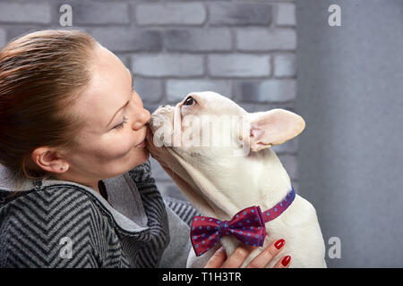 Bouledogue français sur les mains de son maître. Il est estimé que la fille aime son animal de compagnie et les embrassades et l'embrasser. Banque D'Images