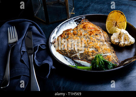 Filet de flétan rôti dans une poêle avec des herbes et du citron Banque D'Images