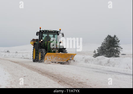 Le tracteur équipé de chasse-neige déneigement route couverte à Dartmoor Banque D'Images