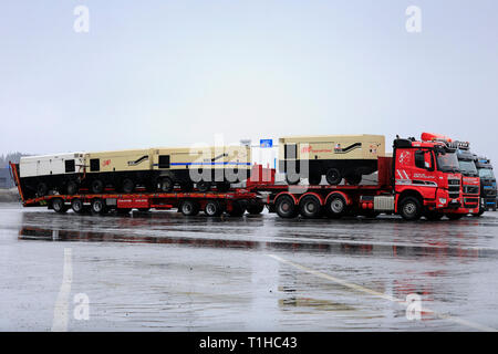 Forssa, Finlande - le 23 mars 2019 : Polar Sisu chariot avec une charge de trois compresseurs d'Ingersoll Rand sur un arrêt de camion dans la pluie, vue de côté. Banque D'Images