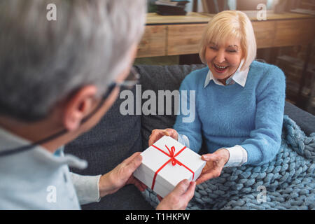 Close up et couper vue de vieil homme en donnant un cadeau à hai épouse. Il l Banque D'Images