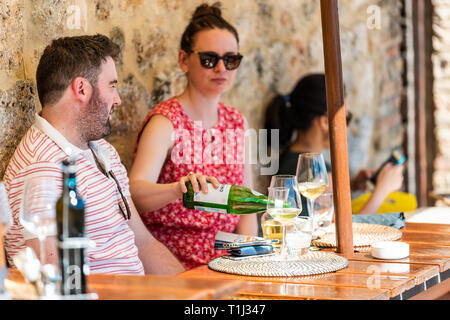 San Gimignano, Italie - 27 août 2018 : young couple sitting boire du vin de manger au café restaurant dégustation dans petite ville village de Toscane d Banque D'Images