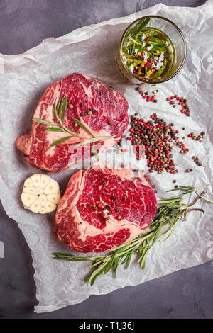 Les viandes steak sur un papier cuisson prêt à rôtir Banque D'Images