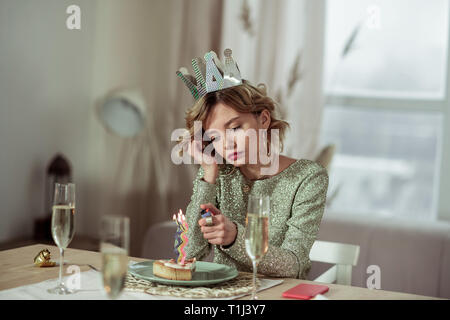 Anniversaire femme à l'aide d'allumer une bougie plus léger sur morceau de gâteau Banque D'Images