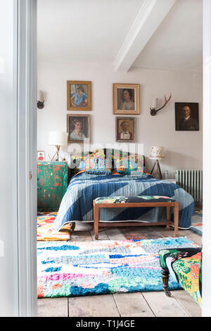 La chambre des maîtres, doté d''un lit Vibrant blue et tapis multicolores Banque D'Images