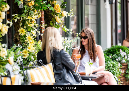 Londres, Royaume-Uni - 23 juin 2018 : deux jeunes femmes girl friends assis à boire des boissons au café en plein air table restaurant à l'extérieur au cours du trottoir de la rue Banque D'Images