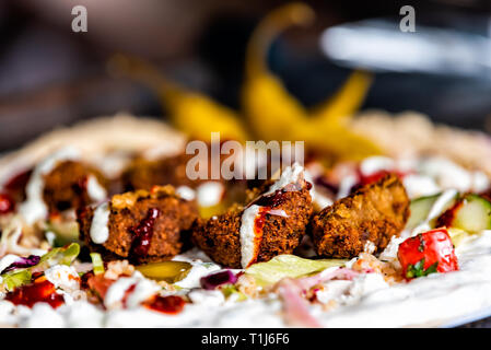 Gros plan macro de falafel envelopper de viande et de pois chiches frits balls avec légumes et sauce pain Banque D'Images